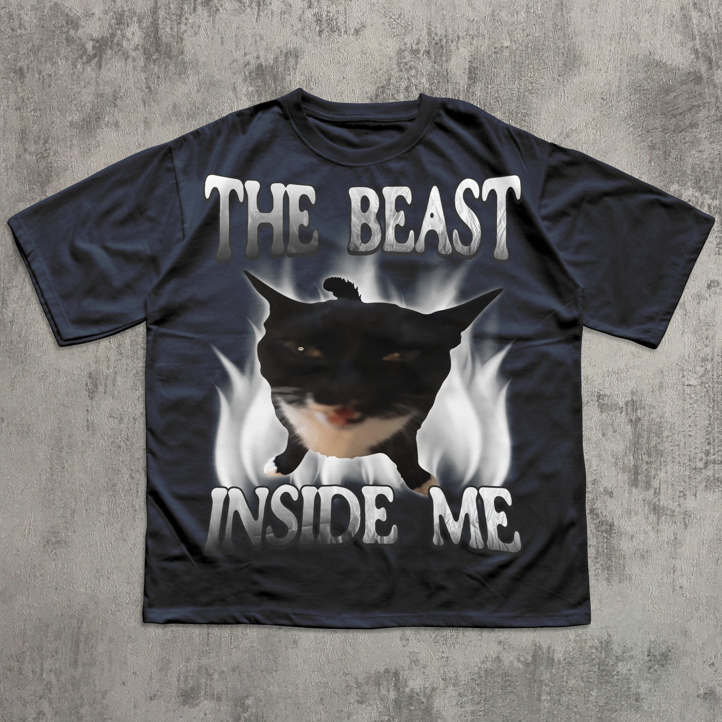 Black t-shirt with a graphic of a dog and text 'The Beast Inside Me' on a concrete surface.