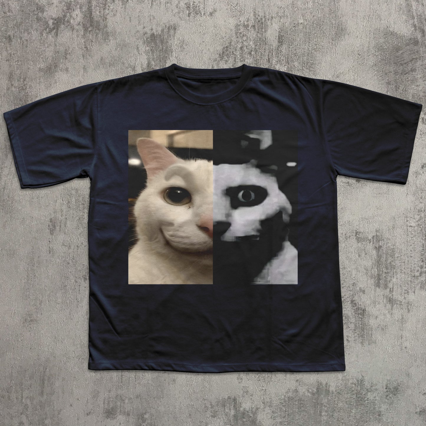 Navy blue t-shirt with a graphic of a cat's face split in half, one side white and one side black, on a textured gray background.