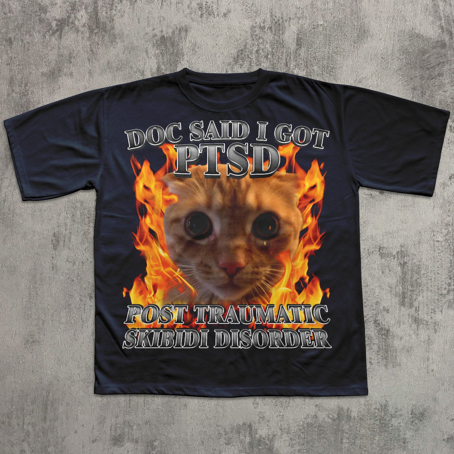 Black t-shirt with a cat graphic and text on a concrete surface