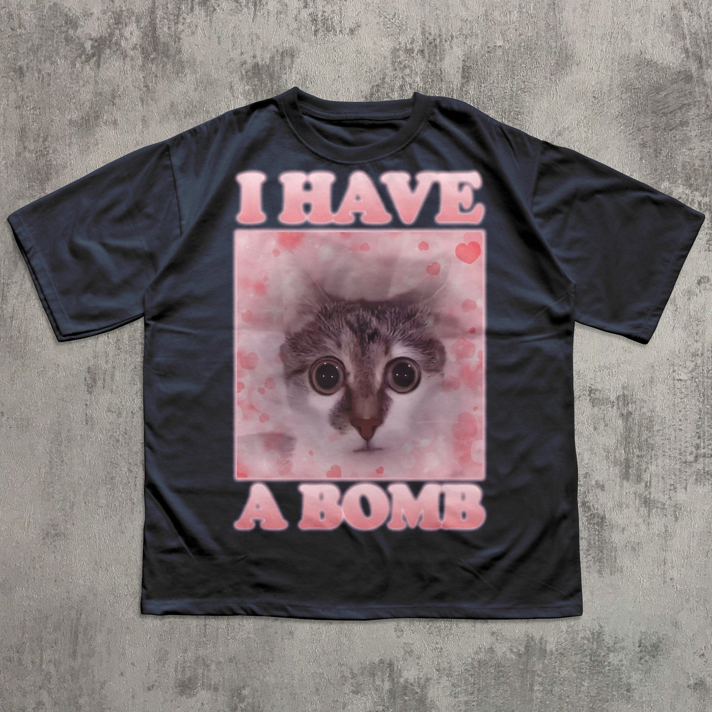 Black t-shirt with a graphic of a cat and text 'I HAVE A BOMB' on a textured gray background