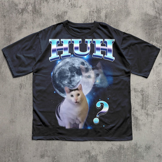Black t-shirt with a cat graphic and 'HUH?' text on a textured gray background