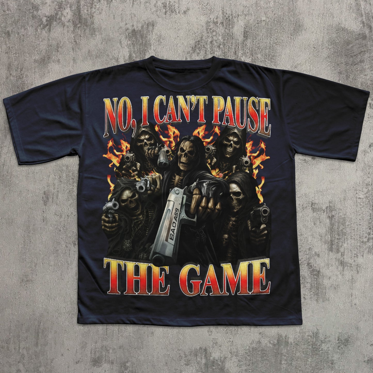 Black t-shirt with graphic design of skeletons holding guns and text 'No, I Can't Pause The Game' on a concrete surface.