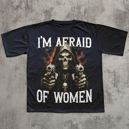 Black t-shirt with a graphic of a skeleton holding guns and text 'I'm Afraid of Women' on a concrete surface.
