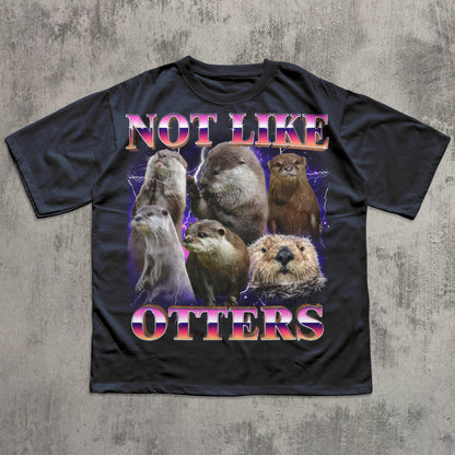 Black t-shirt with otter graphic and text 'Not Like Otters' on a textured gray background