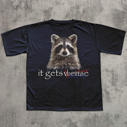 Black t-shirt with a raccoon graphic and 'it gets better' text on a textured gray background