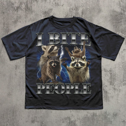 Black t-shirt with raccoon graphic and text 'I BITE PEOPLE' on a textured gray background