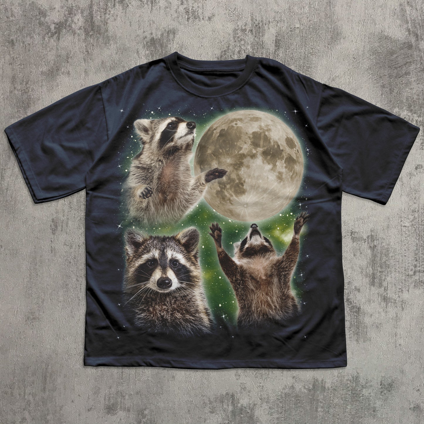Black t-shirt with raccoon graphic and moon on a textured gray background