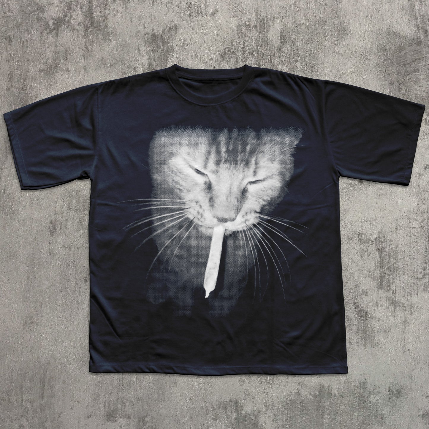Black t-shirt with a cat graphic on a textured gray surface