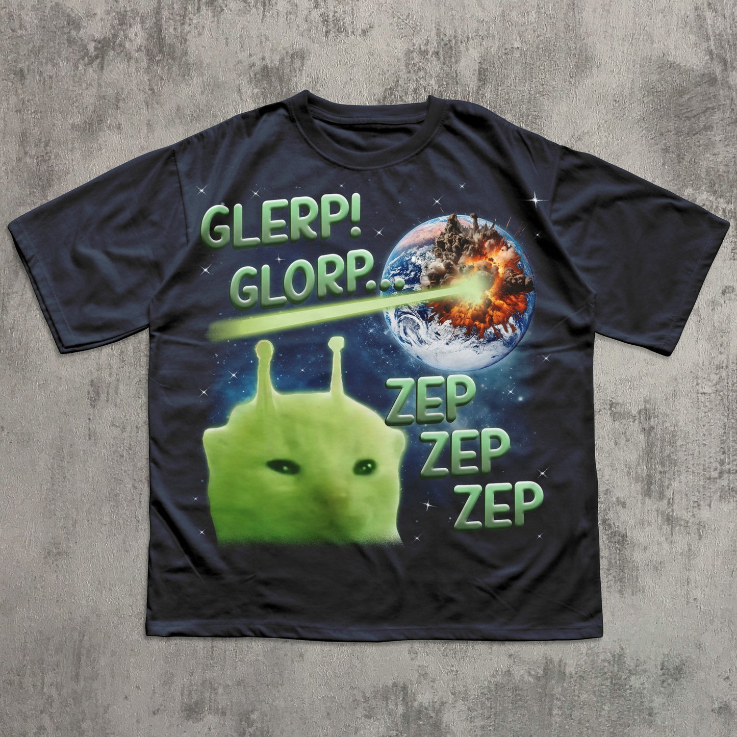 Black t-shirt with a green alien and space-themed design on a concrete surface