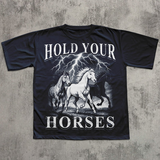 Black t-shirt with graphic of horses and 'Hold Your Horses' text on a textured gray background