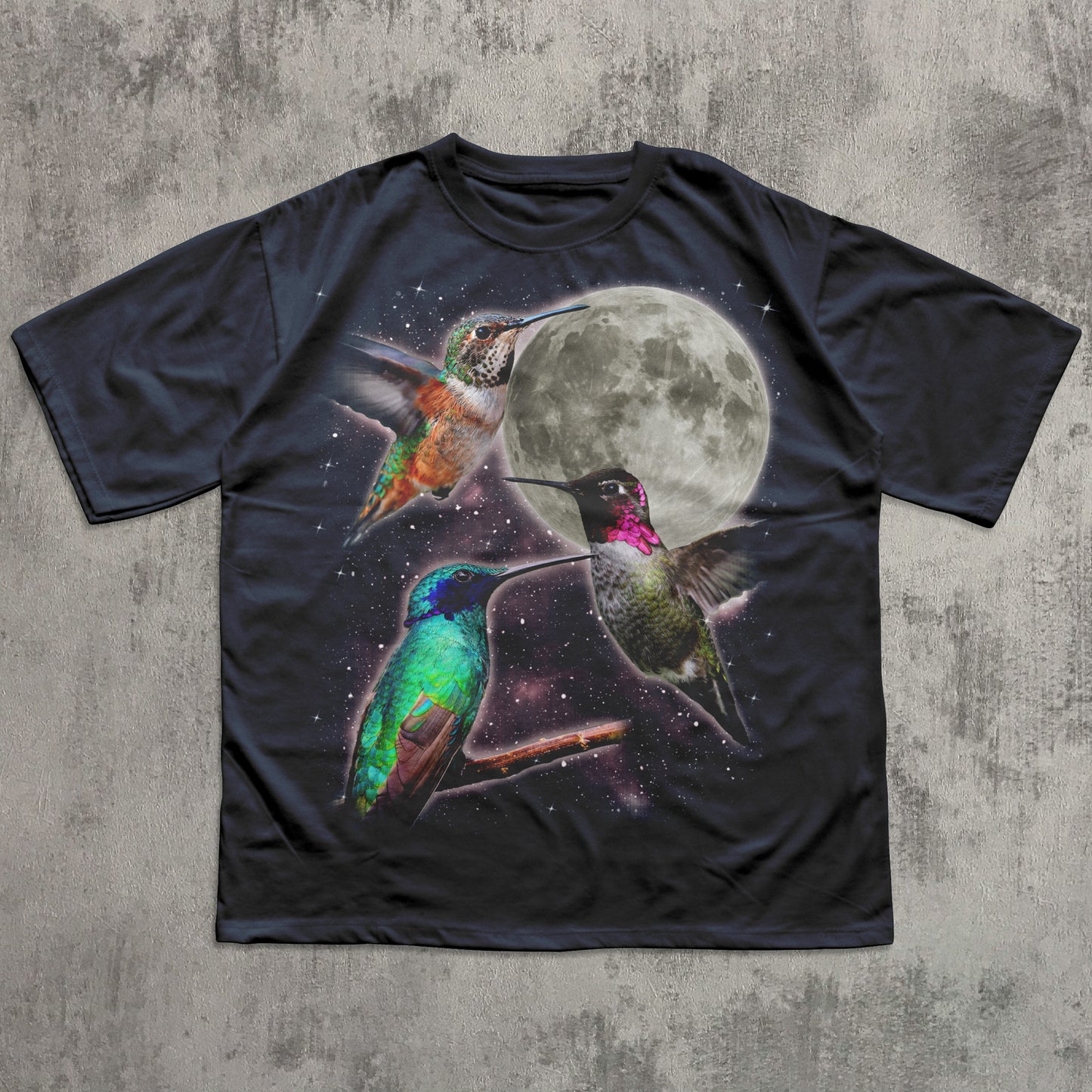 Black t-shirt with colorful hummingbird design and moon on a textured gray background