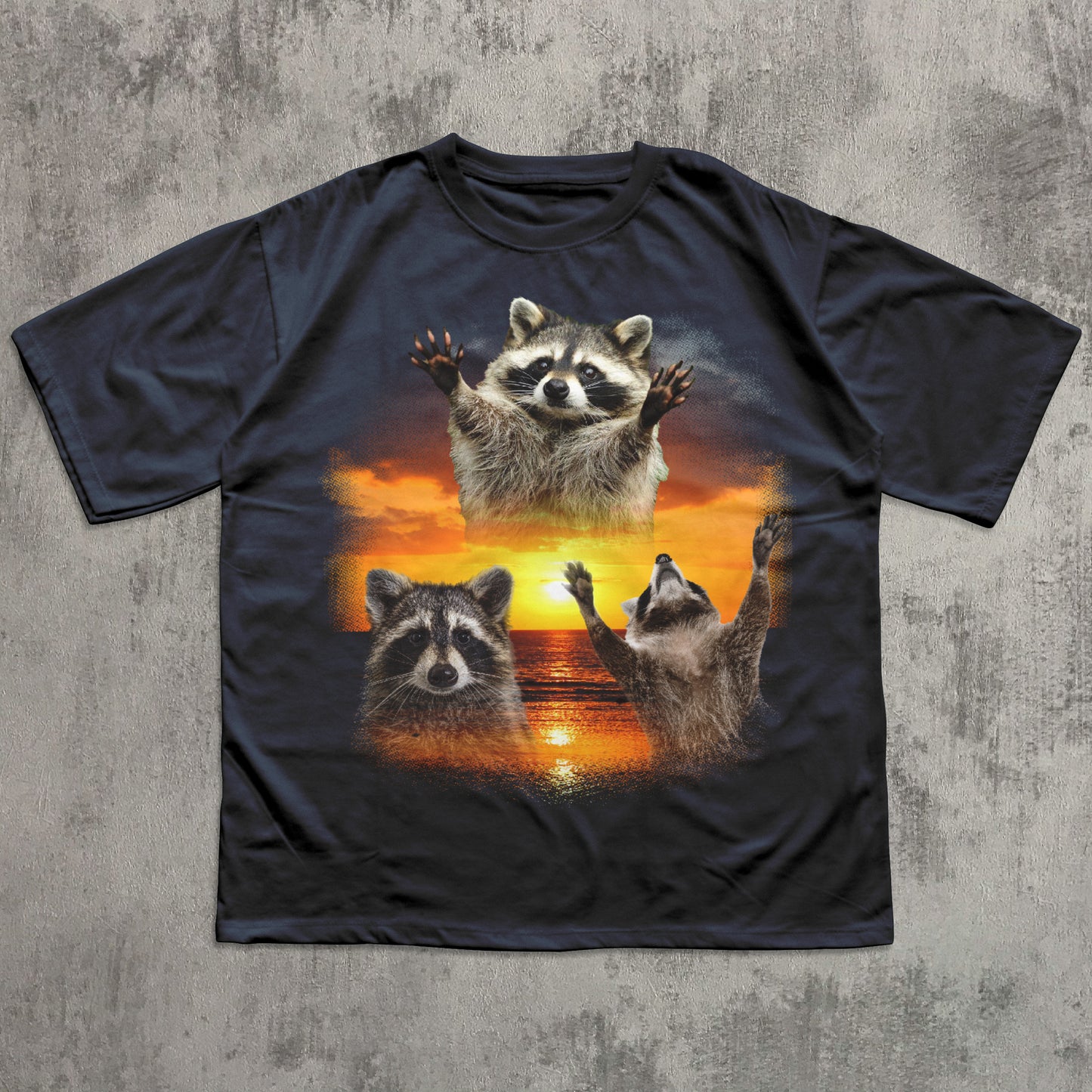 Black t-shirt with raccoon design on a textured gray background