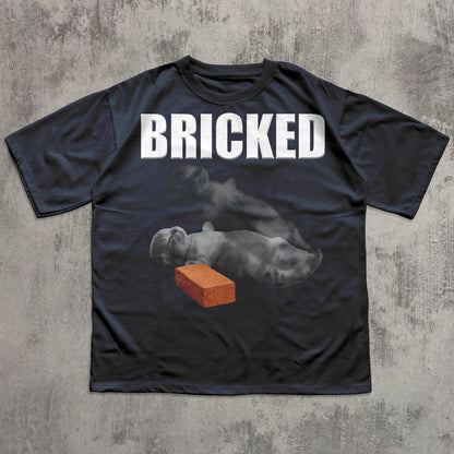 Black t-shirt with 'BRICKED' text and graphic of a Cat with a brick on a concrete background