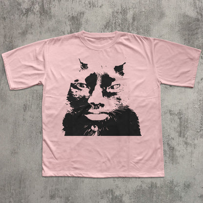 Pink t-shirt with a black cat graphic on a textured gray background