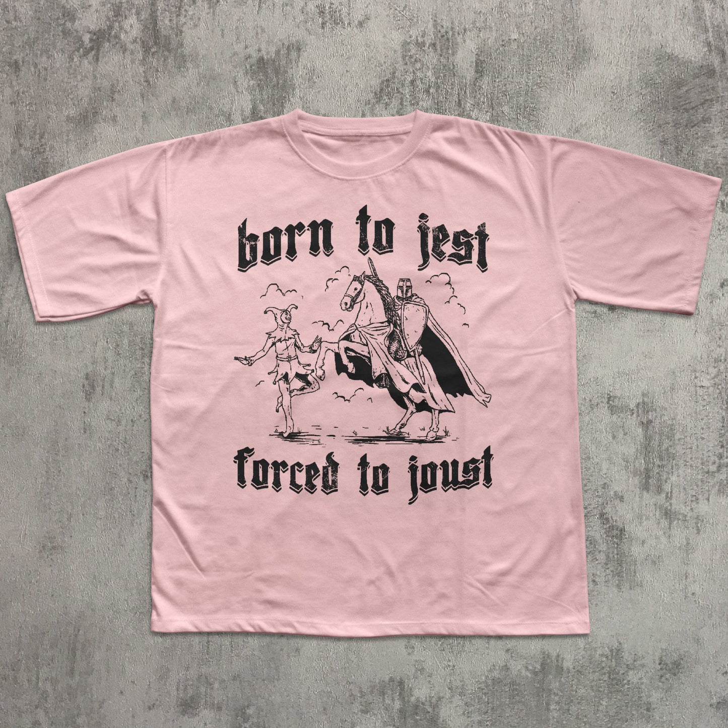 Pink t-shirt with black graphic and text on a textured gray background