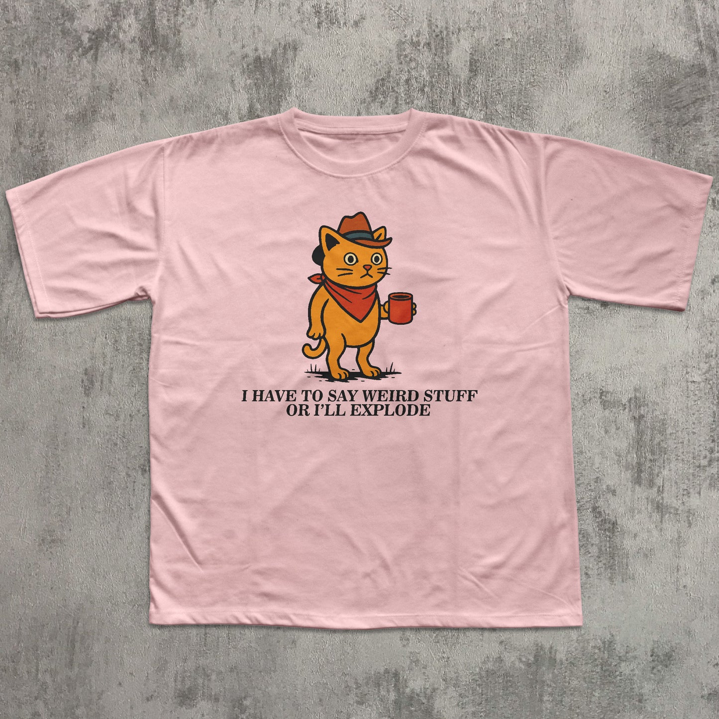 Pink t-shirt with a cartoon cat graphic and text on a gray concrete background