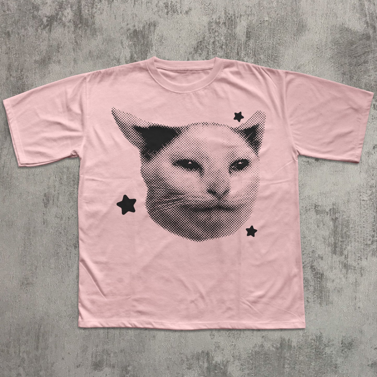 Pink t-shirt with a cat graphic design on a textured gray background