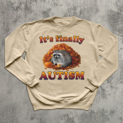 Beige sweatshirt with raccoon and autumn design on a textured gray background