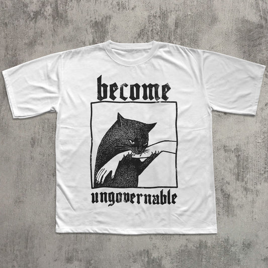 White t-shirt with black graphic and text 'become ungovernable' on a textured gray background