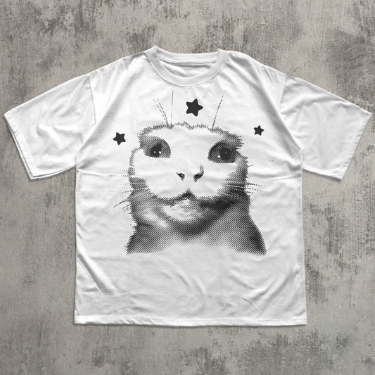 White t-shirt with a black and white cat graphic on a gray concrete surface