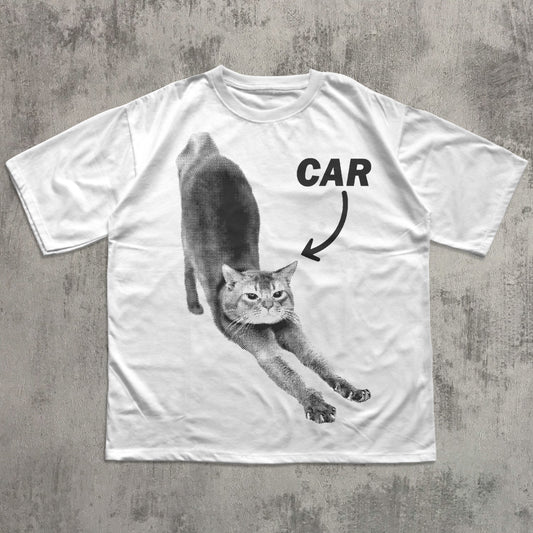 White t-shirt with a graphic of a cat and the word 'CAR' on a concrete surface