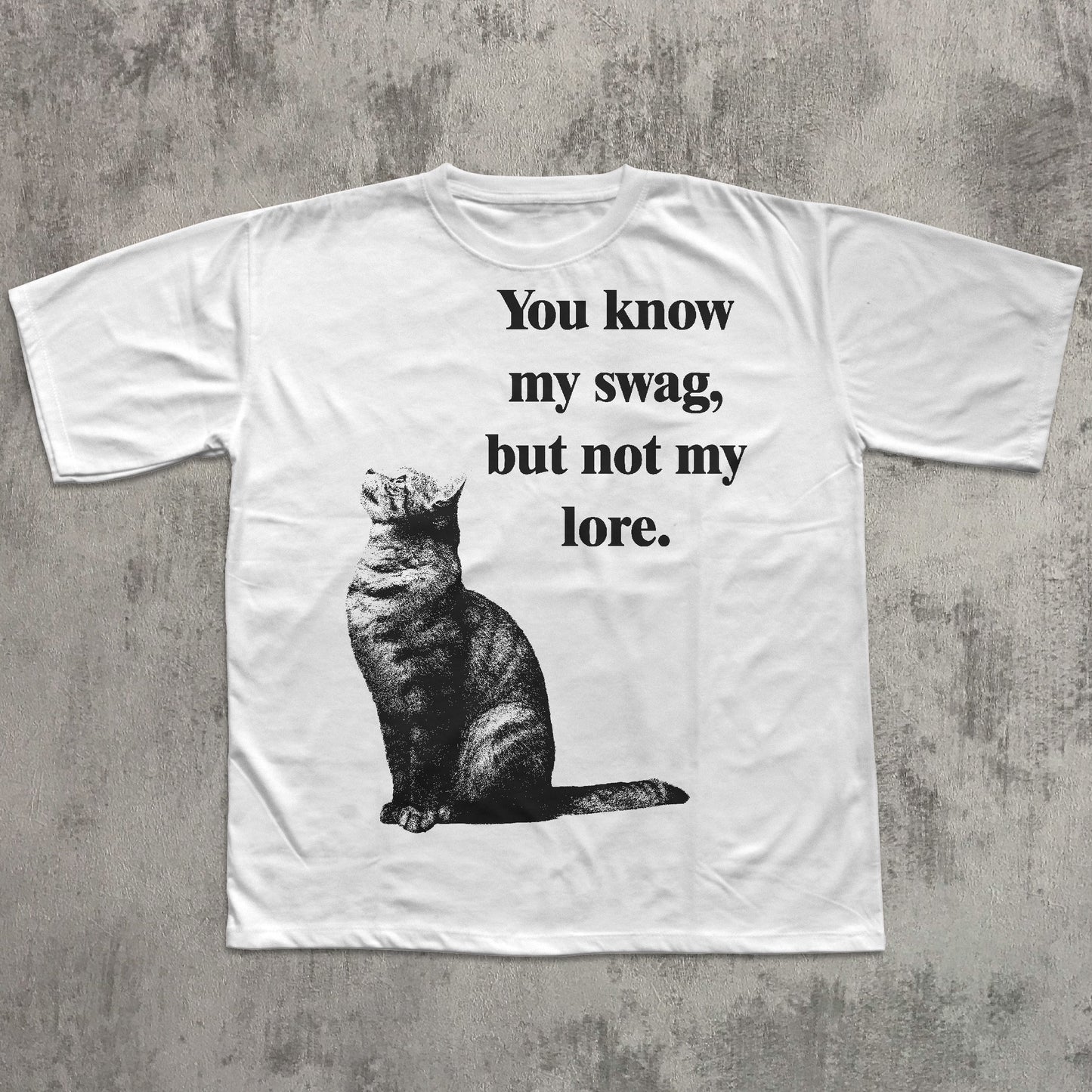 White t-shirt with a cat graphic and text on a textured gray background