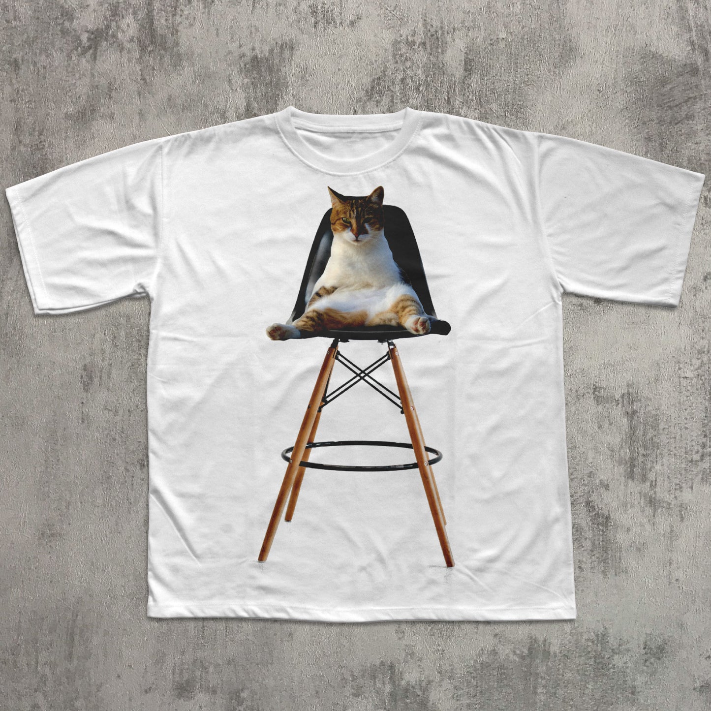 White t-shirt with a graphic of a cat on a chair against a concrete wall background