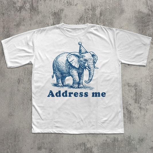 White t-shirt with blue elephant graphic and 'Address me' text on a textured gray background