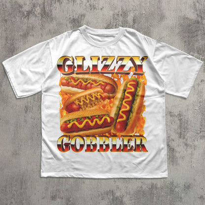 White t-shirt with 'Glizzy Gobbler' hot dog graphic on a concrete surface