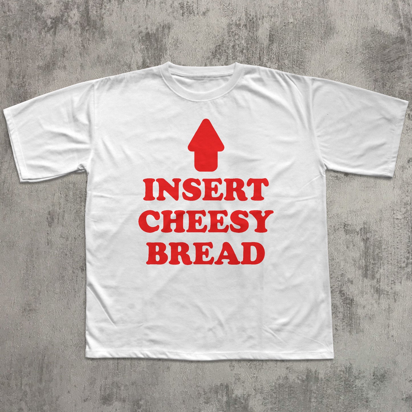 White t-shirt with red text and arrow graphic on a gray concrete background