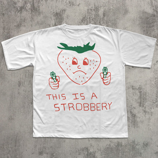White t-shirt with a strawberry graphic and text on a concrete surface