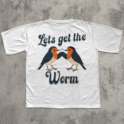 White t-shirt with two birds and text 'Let's get the Worm' on a concrete surface