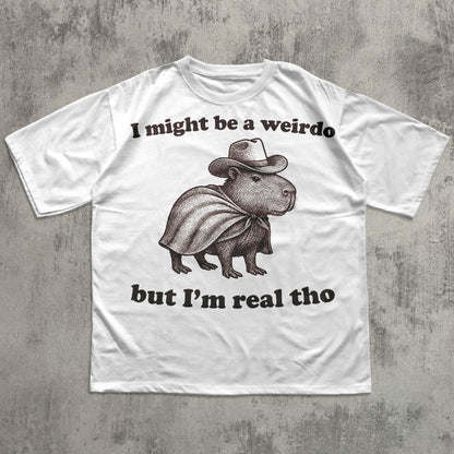 White funny t-shirt with a graphic of a capybara wearing a cowboy hat and text on a concrete surface